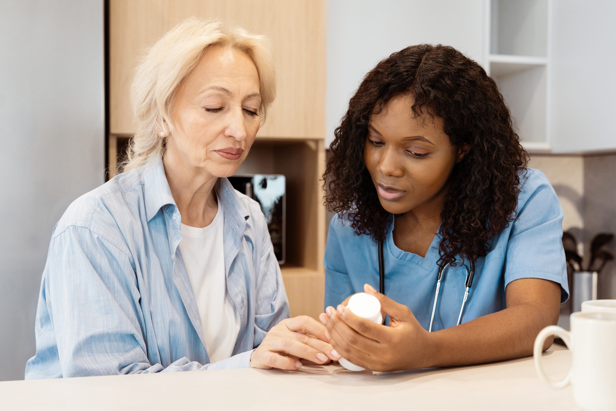 Nurse,Assisting,Senior,Woman,With,Medication,In,Home,Environment